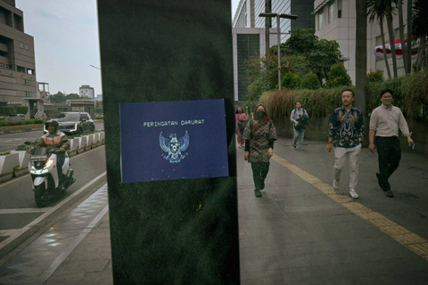 Foto multiple exposure antara pekerja Sudirman dengan seruan Peringatan Darurat di ruang publik. Foto: Jamal Ramadhan/kumparan