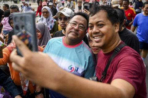Bakal calon Wakil Gubernur DKI Jakarta Rano Karno (kiri) berswafoto dengan warga saat Hari Bebas Kendaraan Bermotor (HBKB) di Bundaran HI, Jakarta, Minggu (1/9/2024). Foto: Rivan Awal Lingga/ANTARA FOTO