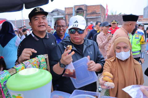 Pj Wali Kota Palembang, A Damenta, mencoba jajanan UMKM di lokasi CFD. (foto: dok. Kominfo Palembang)