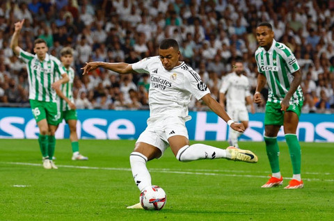 Pemain Real Madrid Kylian Mbappe saat mengeksekusi tendangan penalti saat menghadapi Real Betis. Foto: Susana Vera/REUTERS
