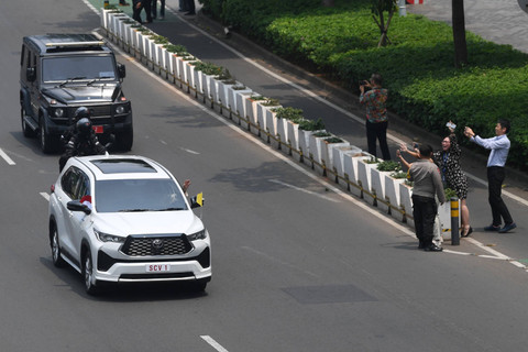 Warga melambaikan tangan ke mobil yang membawa Pemimpin Gereja Katolik Dunia Paus Fransiskus saat melintasi Jalan Jenderal Sudirman, Jakarta, Selasa (3/9/2024).  Foto: Akbar Nugroho Gumay/ANTARA FOTO