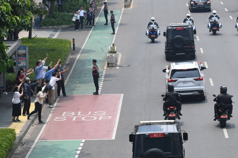 Warga melambaikan tangan ke mobil yang membawa Pemimpin Gereja Katolik Dunia Paus Fransiskus saat melintasi Jalan Jenderal Sudirman, Jakarta, Selasa (3/9/2024).  Foto: Akbar Nugroho Gumay/ANTARA FOTO