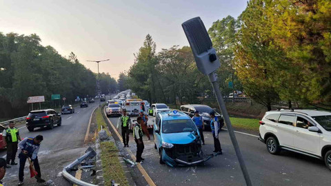 Petugas Jasamarga mengevakuasi mobil taksi no pol B.1091 WUC yang menabrak pembatas dan lampu penerangan jalan di pintu tol Pondok Aren, Tangerang Selatan, Kamis (5/9).  Foto: Aditia Noviansyah/kumparan