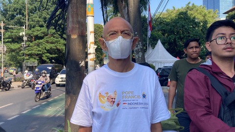 Warga menggunakan pakaian putih bermotif gambar Paus Fransiskus dalam menyambut kedatangannya di Kantor KWI, Jakarta Pusat, Kamis (5/9/2024).  Foto: Alya Zahra/Kumparan