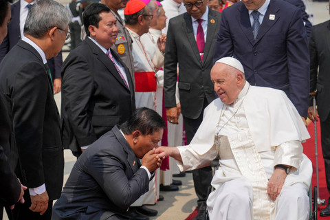 Seorang pria mencium tangan Paus Fransiskus saat keberangkataannya menuju Papua Nugini usai berkunjung ke Indonesia id Bandara Internasional Soekarno-Hatta Jakarta, Indonesia, Jumat, 6 September 2024.  Foto: Tatan Syuflana/Pool via REUTERS