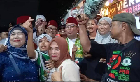 Pria bertopi terbalik (paling kanan) yang sebelumnya terlihat marah saat RK datang malah ikut nimbrung foto bareng RK saat ia ingin pergi. Foto: Dok. kumparan