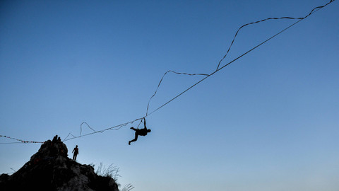 Pegiat olahraga ekstrem terjatuh berjalan di atas tali webbing pada acara Indonesia Highline Festival di Tebing Hawu, Padalarang, Kabupaten Bandung Barat, Jawa Barat, Sabtu (7/9/2024). Foto: ANTARA FOTO/Raisan Al Farisi