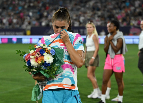 Alex Morgan menangis sembari membawa bunga pada laga pertandingan terakhirnya dalam pertandingan San Diego Wave FC melawan North Carolina Courage di Stadion Snapdragon, San Diego, California, Senin (9/9/2024).  Foto: Jonathan Hui/Reuters