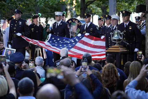 Beberapa pengunjung meletakkan bendera AS di Ground Zero tragedi 9/11 Foto: AP Photo/ Pamela Smith
