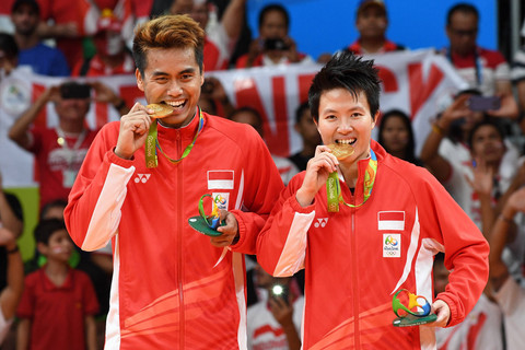 Peraih medali emas dari Indonesia, Tontowi Ahmad dan Liliyana Natsir memegang medali mereka di podium setelah pertandingan bulutangkis medali emas ganda campuran di stadion Riocentro, Rio de Janeiro pada tanggal 17 Agustus 2016, di Olimpiade Rio. Foto: GOH Chai Hin / AFP