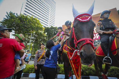 Sejumlah warga dan anak berinteraksi dengan Polisi Berkuda dari Detasemen Turangga Direktorat Polisi Satwa Polri saat Car Free Day (CFD) atau Hari Bebas Kendaraan Bermotor di kawasan Bundaran HI, Jakarta, Minggu (15/9/2024). Foto: Iqbal Firdaus/kumparan
