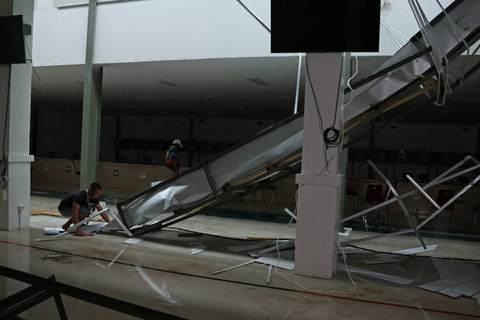 Pekerja membersihkan puing talang air yang ambruk di venue lapangan tembak indoor 10 meter PON XXI Aceh-Sumut 2024 di Lapangan Tembak Rindam IM Mata Ie, Aceh Besar, Aceh, Selasa (17/9/2024). Foto: Arnas Padda/ANTARA FOTO