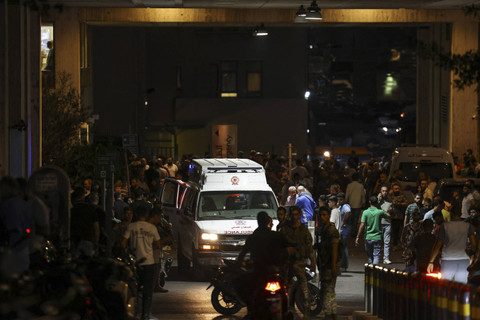 Ambulans dikerumuni orang-orang di pintu masuk American University of Beirut Medical Center ketika pager yang mereka gunakan untuk berkomunikasi meledak di seluruh Lebanon, menurut sumber keamanan, di Beirut, Lebanon, Selasa (17/9/2024). Foto: Anwar Amro/AFP