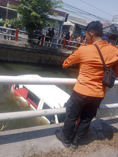 Angkutan feeder Wara Wiri mengangkut 4 orang jatuh ke sungai Jalan Medokan Sawah Depan nomor 71, Kelurahan Medokan Ayu, Kecamatan Rungkut, Surabaya pada Kamis (19/8/2024). Foto: Dok. BPBD Surabaya