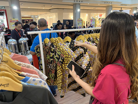 Pengunjung  melihat-lihat kemeja batik bertema Pikachu yang dijual di booth merchandise Pikachu's Indonesia Journey, Jumat (20/9).   Foto: Gitario Vista Inasis/kumparan