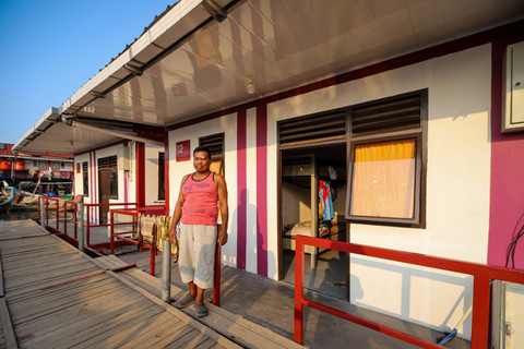 Seorang nelayan berdiri di depan rumah apung di Muara Angke, Jakarta Utara. Foto: Iqbal Firdaus/kumparan
