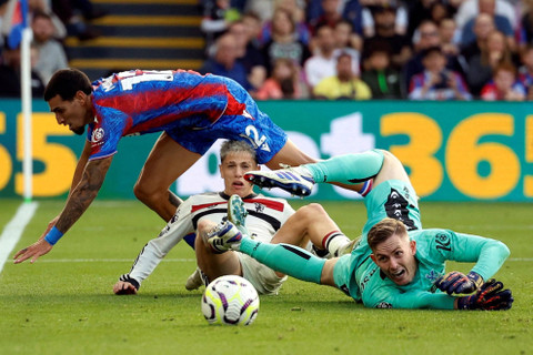 Penjaga gawang Crystal Palace Dean Henderson berebut bola dengan pemain Manchester United Alejandro Garnacho pada pertandingan Liga Inggris di Selhurst Park, London, Inggris, Sabtu (21/9/2024). Foto: Peter Cziborra/REUTERS 