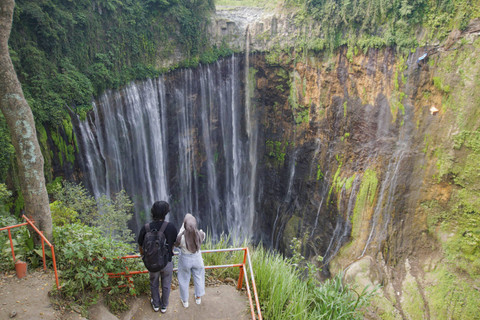 Wisatawan memperlihatkan aplikasi informasi wisata melalui ponsel miliknya saat mengunjungi wisata air terjun Tumpak Sewu di Ampelgading, Malang, Jawa Timur, Minggu (22/9/2024). Foto: Irfan Sumanjaya/ANTARA FOTO