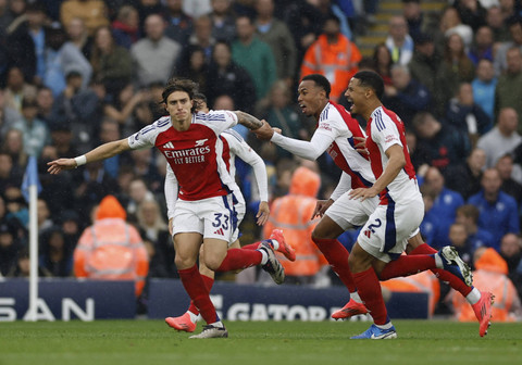 Pemain Arsenal, Riccardo Calafiori, merayakan gol pertama mereka dengan Gabriel Magalhaes dan William Saliba pada pertandingan Liga Inggris antara Manchester City melawan Arsenal di Stadion Etihad, Manchester, Inggris, Minggu (22/9/2024). Foto: Jason Cairnduff/REUTERS