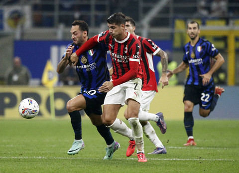 Duel Hakan Calhanoglu dengan Alvaro Morata saat Inter vs AC Milan dalam laga pekan kelima Liga Italia 2024/25 di Stadion San Siro, Senin (23/9) dini hari WIB. Foto: REUTERS/Alessandro Garofalo