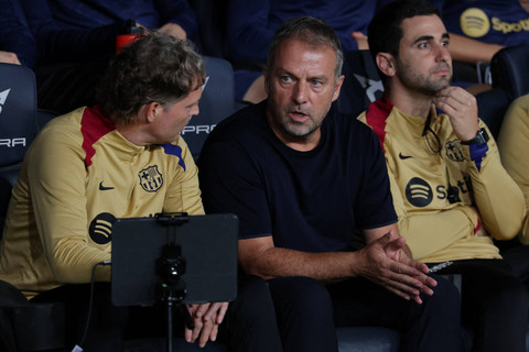Pelatih Barcelona Hansi Flick berbincang dengan staf pelatihnya saat Barcelona melawan Getafe pada pekan ketujuh Liga Spanyol di Estadio Olimpic Lluis Companys, Barcelona, Rabu (25/9/2024). Foto: LLUIS GENE/AFP