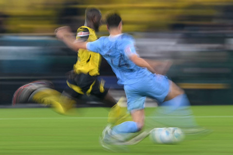 Pemain Borussia Dortmund Serhou Guirassy menendang bola yang coba dihalau pemain VFL Bochum Tim Oermann pada pertandingan Bundesliga Jerman di Signal Iduna Park, Dortmund, Jerman, Jumat (27/9/2024). Foto: Ina Fassbender/AFP