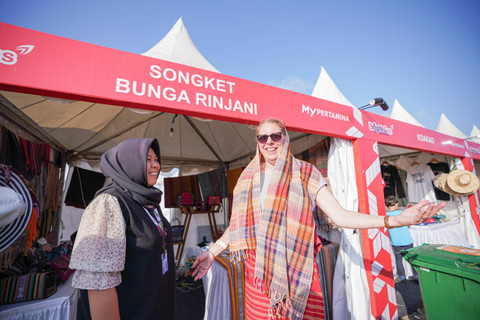 Salah satu pengunjung Pertamina Grand Prix of Indonesia, Susie Gait asal Inggris, membeli songket khas Lombok. Dok: Pertamina Patra Niaga
