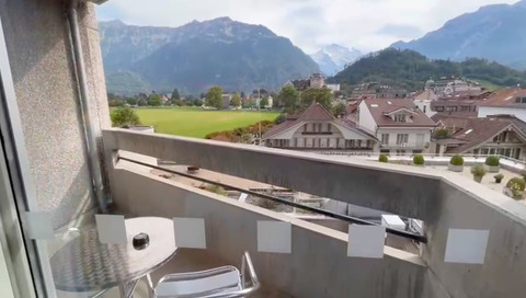 Dari balkon Hotel Metropole ini, kita bisa melihat turis yang paralayang mendarat tepat di depan alun-alun Interlaken. Foto: Reza Aditya Ramadhan/kumparan