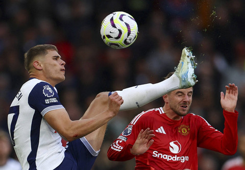 Micky van de Ven dari Tottenham Hotspur beraksi dengan pemain Manchester United, Mason Mount pada pertandingan Liga Inggris saat Manchester United melawan Tottenham Hotspur di Old Trafford, Manchester, Inggris, Senin (30/9/2024). Foto: Molly Darlington/REUTERS