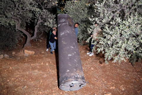 Warga Palestina menemukan proyektil, setelah Iran menembakkan salvo rudal balistik, di Tubas, di Tepi Barat yang diduduki Israel, 1 Oktober 2024. Foto: REUTERS/Raneen Sawafta