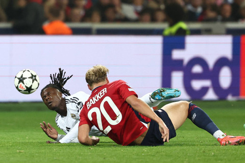 Pemain Lille Mitchel Bakker berebut bola dengan pemain Real Madrid Eduardo Camavinga pada pertandingan Liga Champions di Decathlon Arena Stade Pierre-Mauroy, Prancis, Rabu (2/10/2024). Foto: Sameer Al-Doumy / AFP