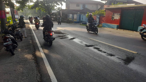 Pemotor berhati-hati melintasi jalanan yang tercemar oli. Dok: kumparan.