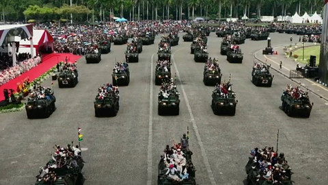 Sejumlah warga mengikuti defile kendaraan alutsista saat peringatan HUT ke-79 TNI di kawasan Monumen Nasional, Jakarta, Sabtu (5/10/2024). Foto: Youtube/Puspen TNI