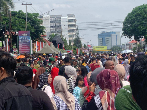 Ratusan masyarakat Palembang saat berkumpul di Jalan Sudirman untuk menyaksikan defile alutsista TNI di perayaan HUT ke-79 TNI, Foto : Abdullah Toriq/Urban Id