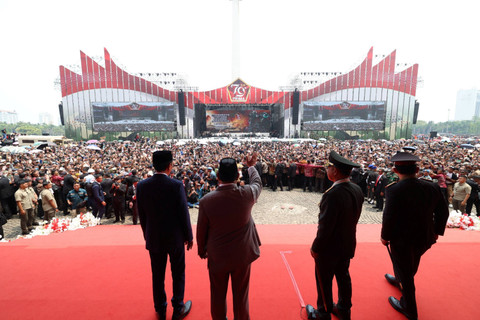 Presiden Jokowi (tengah) dan menteri Pertahanan sekaligus presiden terpilih 2024-2029 Prabowo Subianto menyapa para warga usai menghadiri upacara peringatan HUT ke-79 TNI di kawasan Monumen Nasional, Jakarta, Sabtu (5/10/2024). Foto: Dok. Istimewa
