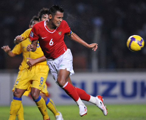 Kapten Indonesia Charis Yulianto (kanan) menyundul bola saat bertarung dengan pemain Thailand Suchao Nutnum (kiri) dalam pertandingan sepak bola AFF Suzuki Cup di Jakarta pada 16 Desember 2008.  Foto: Bay Ismoyo/AFP