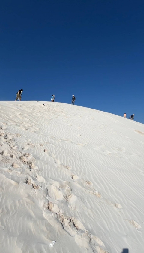 Wisatawan mendaki bukit pasir untuk sandboarding. Foto: Adhie Ichsan/kumparan