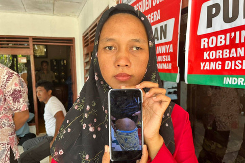 Yuli Yasmi saat menunjukkan foto suaminya yang luka setelah disiksa di perbatasan Thailand dan Myanmar. (10/10/2024), Foto: kumparan