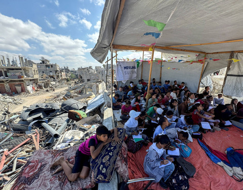Siswa mengikuti kegiatan belajar (KBM) mengajar saat konflik Israel dengan Palestina di tenda sementara Khan Younis, Jalur Gaza Selatan, Kamis (10/10/2024). Foto: M... </div>
<div class=