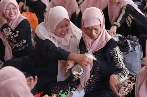 Para jemaan kajian menyemprotkan Kispray ke pakaian. Foto: Jamal Ramadhan/kumparan