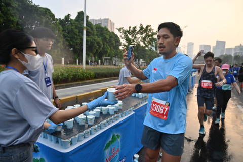 Ibnu Jamil mengambil minum di water station Le Minerale.. Foto: dok. Le Minerale