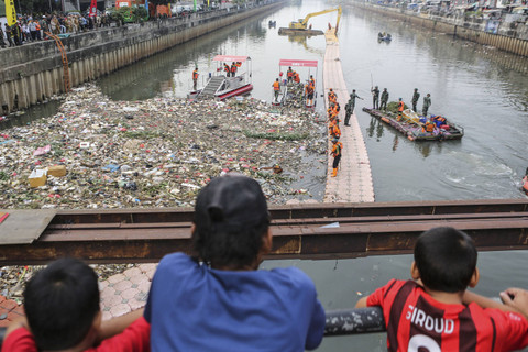 Warga melihat prajurit TNI AD bersama petugas UPS Badan Air membersihkan sampah saat giat Ciliwung Bening di Sungai Ciliwung, Tambora, Jakarta Barat, Minggu (13/10/2024). Foto: Asprilla Dwi Adha/ANTARA FOTO