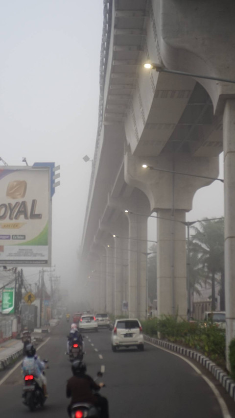 Suasana kabut tebal yang terlihat di sepanjang Jalan Angkatan 45 hingga ke Jalan Demang Lebar Daun Palembang, Senin (14/10) Foto: ary/urban id