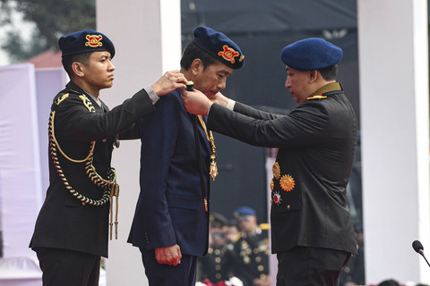 Presiden Joko Widodo (tengah) menerima anugerah medali kehormatan keamanan dan keselamatan publik Loka Praja Samrakshana dari Kapolri Jenderal Polisi Listyo Sigit Prabowo (kanan) di Mako Brimob, Kelapa Dua, Depok, Jawa Barat, Senin (14/10/2024). Foto: Muhammad Adimaja/ANTARA FOTO