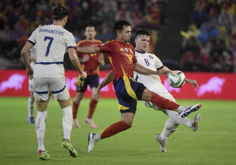 Pemain Spanyol Martin Zubimendi berebut bola pemain Serbia Luka Jovic pada UEFA Nation League di Stadion Nuevo Arcangel, Cordoba, Rabu (15/10/2024). Foto: CRISTINA QUICLER/AFP