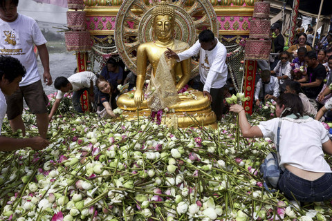 Umat Buddha mengumpulkan bunga teratai setelah mereka menghadiri Festival Pelemparan Teratai, untuk menandai berakhirnya masa Prapaskah Buddha, di Samut Prakan, Thailand, Rabu (16/10/2024). Foto: Chalinee Thirasupa/REUTERS