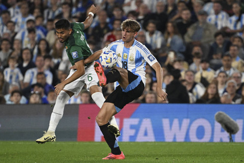 Pemain Bolivia Adalid Terrazas dan pemain Argentina Nico Paz berebut bola pada pertandingan kualifikasi Piala Dunia FIFA 2026 zona Amerika Selatan antara Argentina melawan Bolivia di stadion Mas Monumental, Buenos Aires, Rabu (16/10/2024). Foto: Juan Mabromata/AFP