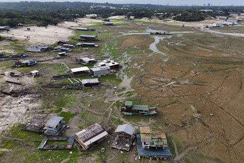 Foto udara rumah-rumah dan perahu berada di dasar saat kekeringan parah di sungai Taruma Acu, hutan hujan Amazon, Manaus, Brasil, Rabu (16/10/2024). Foto: Bruno Kelly/Reuters