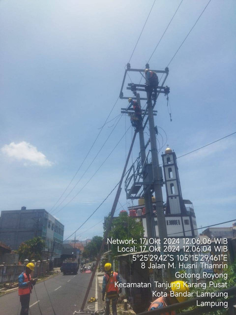 Petugas PLN yang sedang memperbaiki tiang listrik yang rubuh. | Foto: PLN UID Lampung