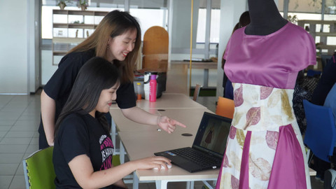 Gisela Charlotte (duduk, rambut hitam) danSharone Hendrata, mahasiswa Petra Christian University bersama produk busana hasil desain menggunakan CLO.